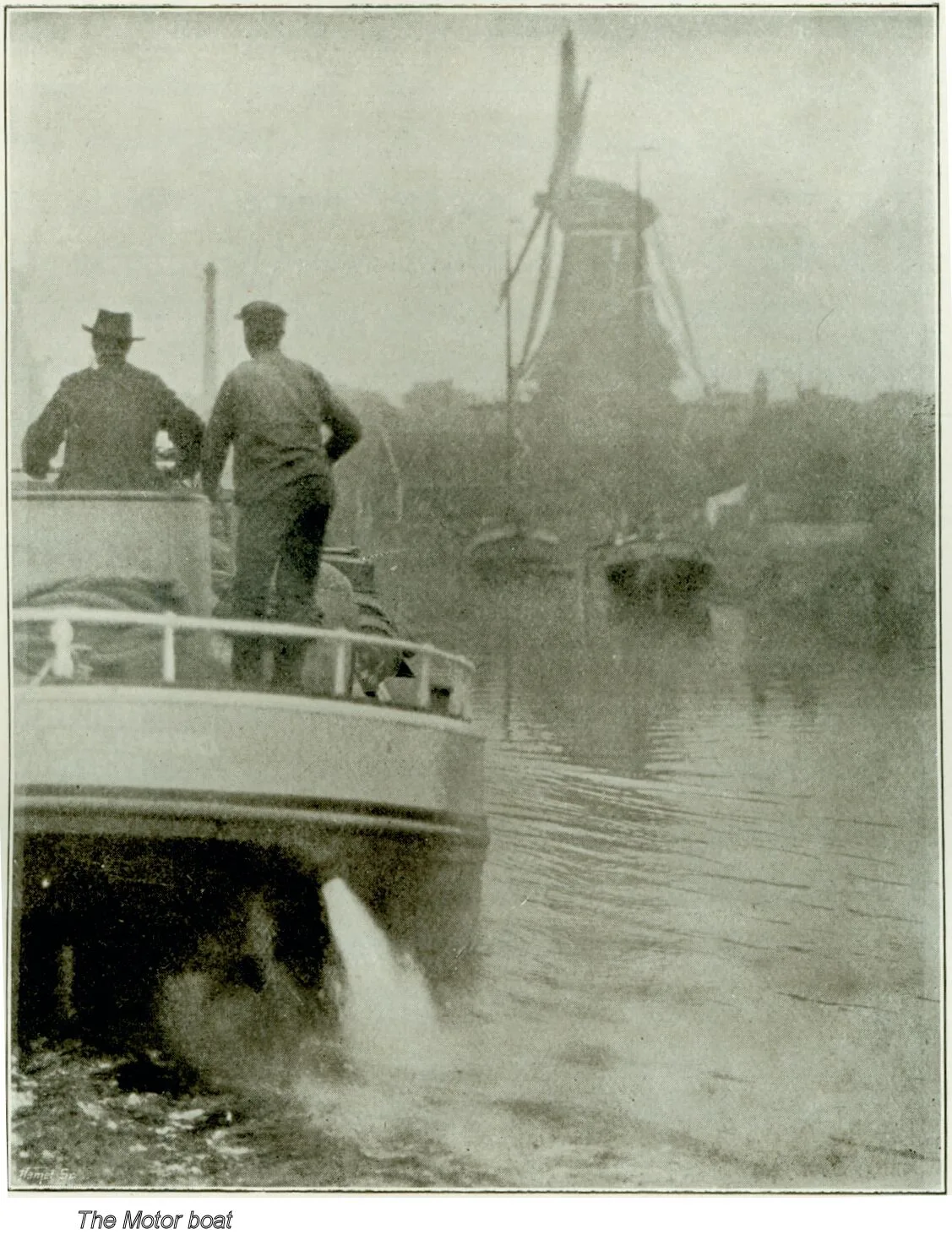 Historische motorboot vaart door Fries water richting een molen, zwart-wit foto uit 1906