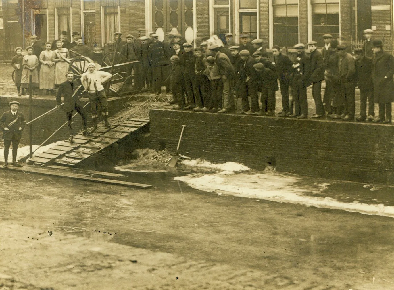 Schaatsers en publiek op de Willemskade in Leeuwarden tijdens de tweede Elfstedentocht op 7 februari 1912