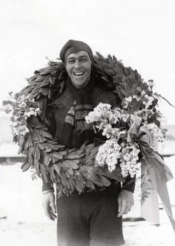 Lachende Auke Adema uit Franeker met grote lauwerkrans om zijn schouders na zijn overwinning in de Elfstedentocht van 6 februari 1941