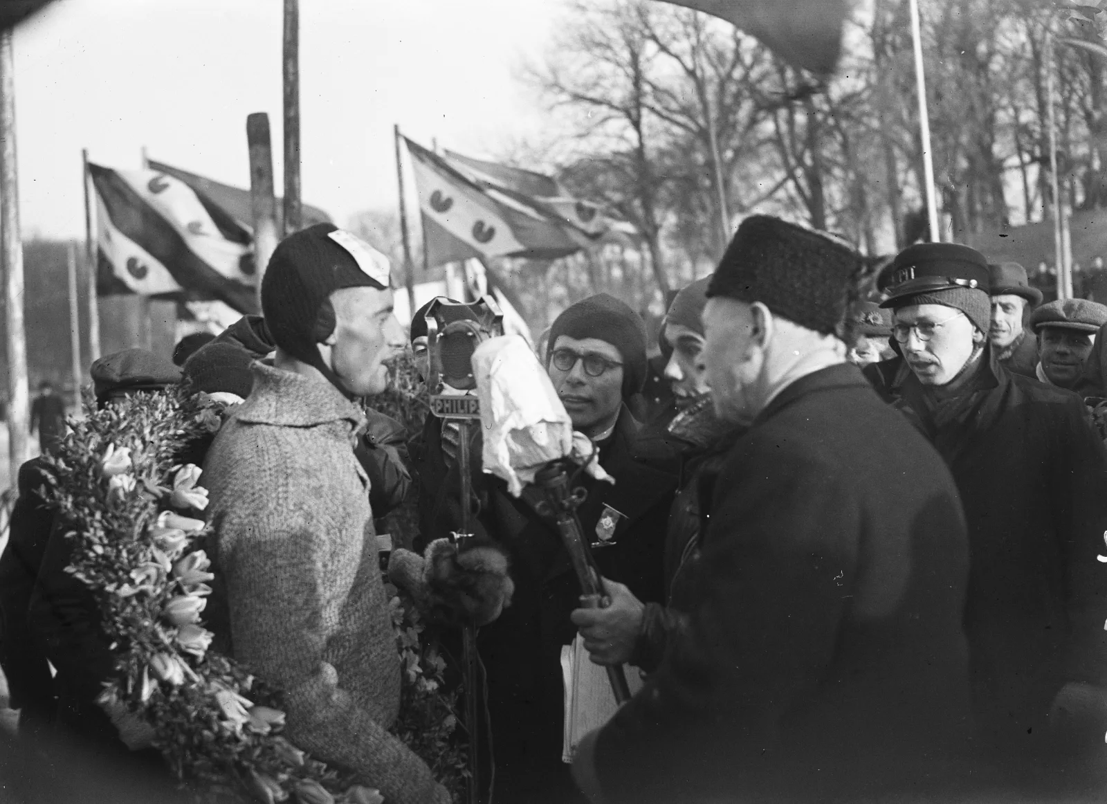 Joop Bosman uit Breukelen wordt gehuldigd als winnaar van de Elfstedentocht op 8 februari 1947, met lauwerkrans en wapperende vlaggen